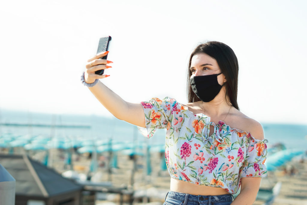 Mujer se toma una selfie en Miami con tapabocas